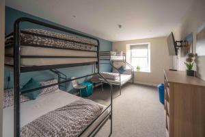 Pokój z 2 łóżkami piętrowymi i biurkiem w obiekcie Newcastleton Bunkhouse w mieście Newcastleton