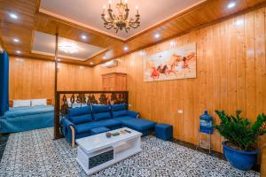 uma sala de estar com um sofá azul e uma mesa em BAO AN RESORT & BUNGALOW em Hòa Bình