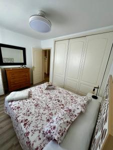 een slaapkamer met een bed met een bloemenbed bij Apartamento con parking en Pedregalejo in Málaga