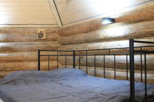 a bed in a room with a wooden wall at Kuukkelin Koto in Hämeenlinna