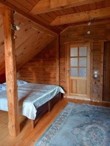 um quarto com 2 camas num chalé de madeira em Kaimo sodyba Senas rublis em Pesčiai