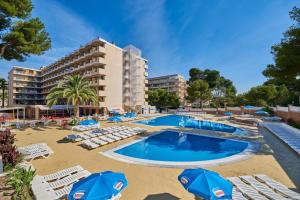 una piscina con sillas y sombrillas y un hotel en Inter 2, en Salou