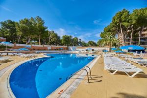 une grande piscine avec des chaises longues et des parasols dans l'établissement Inter 2, à Salou