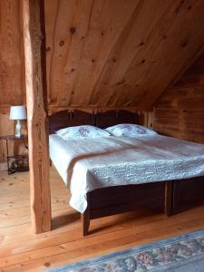 a bedroom with a bed in a wooden cabin at Kaimo sodyba Senas rublis in Pesčiai