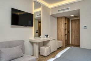 una camera con letto, scrivania e TV di Palatino Hotel a Città di Zante