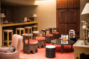 un groupe de tabourets et de tables dans une pièce dans l'établissement Dar Maktoub, à Agadir