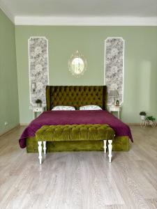 1 dormitorio con 1 cama grande con colcha púrpura en Edem Apartments in Lviv, en Leópolis