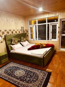 a bedroom with a large bed and a window at D’SHIEKHS RESORT GUREZ in Kanzalwan