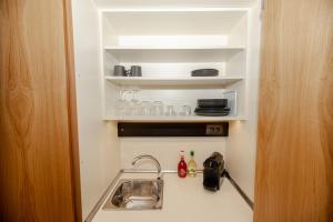 a kitchen with a sink and a shelf with glasses at Fyllis Fine Living Sea view in Asprovalta +134 photos