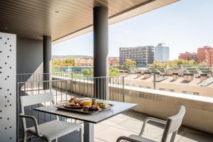 a plate of fruit on a table on a balcony at Hotel SB Plaza Europa in Hospitalet de Llobregat