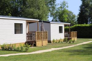 a mobile home with a porch and an american flag at Lodge geschikt voor 4 personen in Wijster