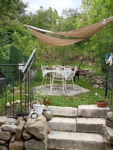 patio con mesa y hamaca en Petit havre de paix en La Bréole