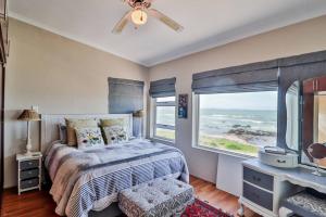 a bedroom with a bed and a window with the ocean at Franskraal Heaven-On-Sea in Franskraal