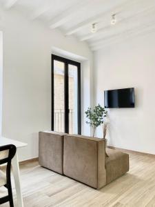 塔拉戈纳Vigablanca Apartments的客厅里，窗前有一张沙发