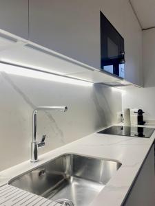 塔拉戈纳Vigablanca Apartments的白色厨房里的不锈钢水槽