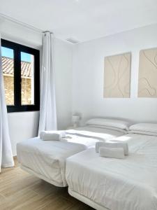 塔拉戈纳Vigablanca Apartments的一间白墙房间里有两张床