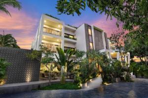 un grande edificio bianco con alberi di fronte di The Calm Oasis a Siem Reap