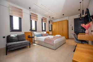 a bedroom with a bed and a couch and a chair at Fyllis Fine Living Sea view in Asprovalta