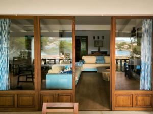 een woonkamer met glazen schuifdeuren en een bank bij Ca Na Marieta House by Slow Villas in Portocolom