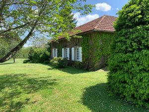 a brick house with ivy on the side of a yard at "Castel" in Saint-Amand-de-Coly