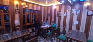 D’SHIEKHS RESORT GUREZ في Kanzalwan: مجموعة من الناس يجلسون على طاولة في مطعم