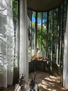 Pokój z dużymi oknami i stołem z herbatą w obiekcie Le Complot : Maison privée en plein coeur d'Avignon w Awinionie