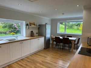 a kitchen and dining room with a table and a refrigerator at Stratheyre Cottage in Portree