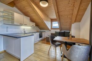 cocina y comedor con techo de madera en Chalet Schlossberg Weißhorn en Nova Ponente