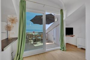 a room with a balcony with a table with an umbrella at Grand View Apartments in Drasnice