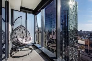 Skyline Allure - Urban Wellness meets City Living في ملبورن: غرفة بها كرسي يتأرجح على مبنى