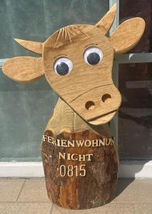 a wooden cow carved out of a tree stump at Schlafen in Erfurt- nicht 0815 in Erfurt