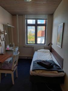 ein Schlafzimmer mit einem Bett, einem Waschbecken und einem Fenster in der Unterkunft Hotel Crone in Grenå