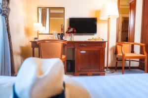 a hotel room with a television and a desk with chairs at BRISTOL Hotel Opatija in Opatija
