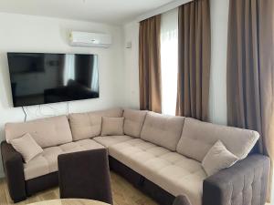 a living room with a couch and a flat screen tv at Tisno Resort in Tisno