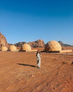 a woman standing in a field in the desert at Wadi Rum Classic camp in Aqaba