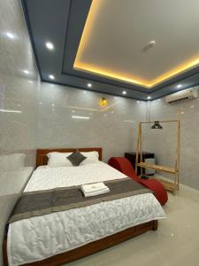 芹苴的住宿－PHÚ PHƯƠNG NAM HOTEL，一间卧室配有一张大床和红色椅子