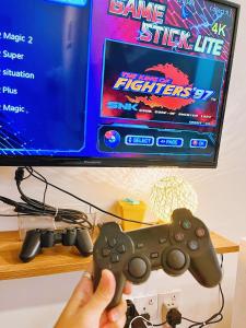 a person holding a video game controller in front of a tv at My Homestay @ Morib Bay Banting in Banting