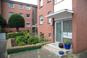 un edificio de ladrillo con plantas delante de una puerta en Othman Appartements Alte Schmiede 2 OG L en Hannover
