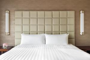 a bedroom with a large bed with white pillows at Shangri-La Fuzhou in Fuzhou
