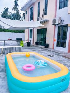 a large inflatable pool in front of a house at My Homestay @ Morib Bay Banting in Banting