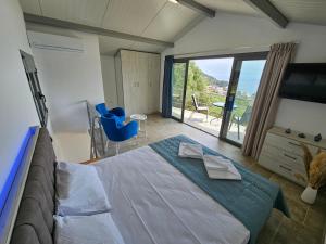 a bedroom with a large bed and a large window at Black Goat in Chrysi Ammoudia