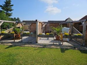 una terraza de madera con macetas en un patio en Störmthal Ferienwohnung 1 Sonnenweg en Störmthal