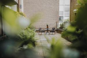 a patio with two chairs and a table in front of a building at DOWNTOWN Apartment mit Luxusbad am Hafen nur 5 Minuten zu Fuß in die Innenstadt! in Oldenburg
