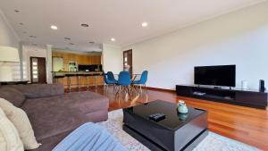 a living room with a couch and a flat screen tv at Capela's House in Ribeira Brava