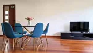 a table with blue chairs and a vase of flowers at Capela's House in Ribeira Brava +46 photos