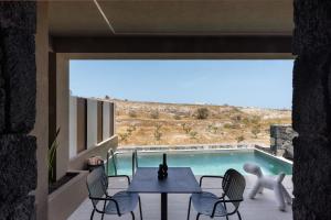 a patio with a table and chairs and a swimming pool at Hidden Hills in Mesaria