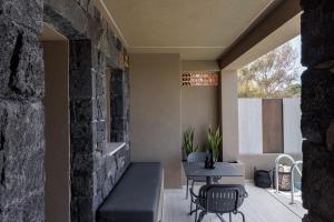 a patio with a table and chairs and a stone wall at Hidden Hills in Mesaria