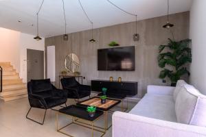- un salon avec un canapé, des chaises et une télévision dans l'établissement כליל הים, à Eilat
