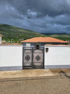 un cancello in una recinzione bianca con una casa di Vila Dolce Vita Mostar a Mostar