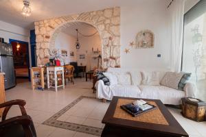 un salon avec un canapé blanc et une table dans l'établissement Poseidon Seafront Apartment by RentalsPro - Siviri Halkidiki, à Siviri